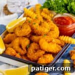 Crispy panko fried shrimp served with fries and cocktail sauce.