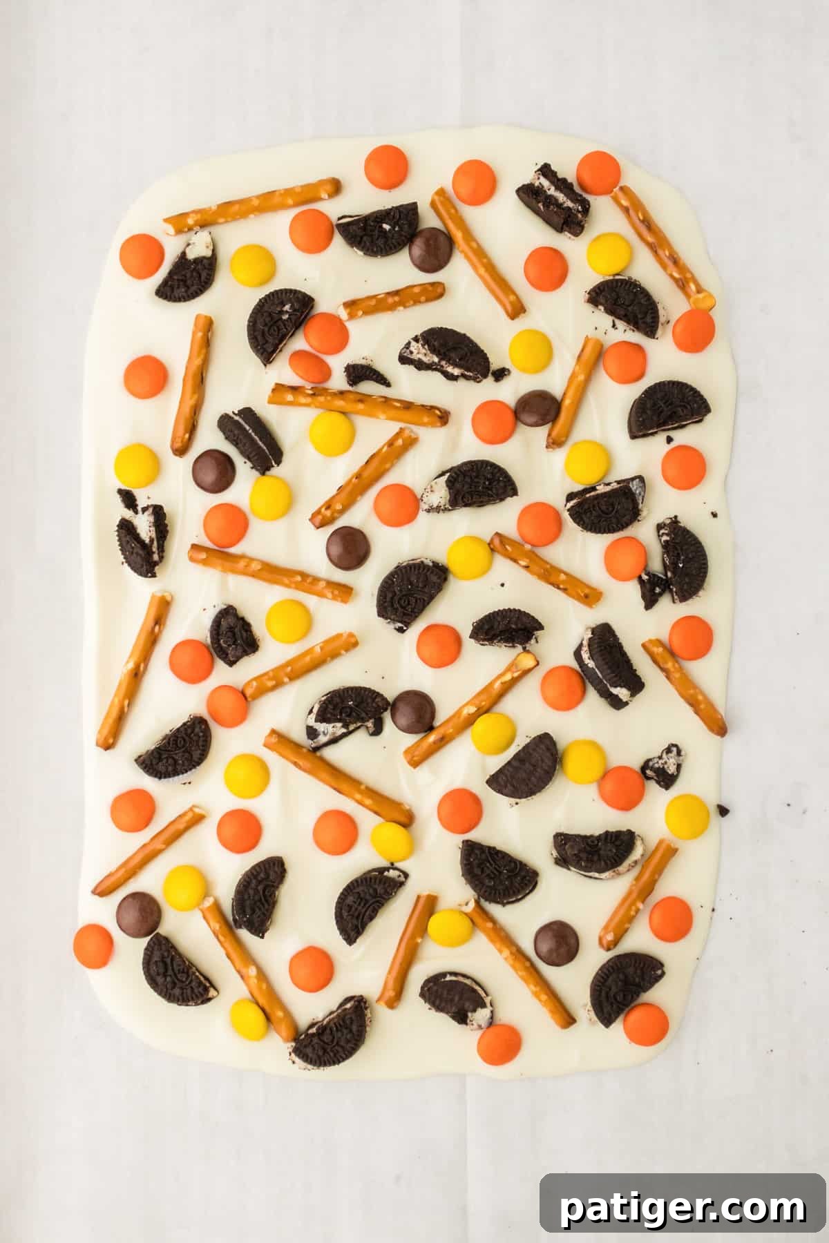 Pretsel sticks, reese's, and oreos pressed into the melted bark.