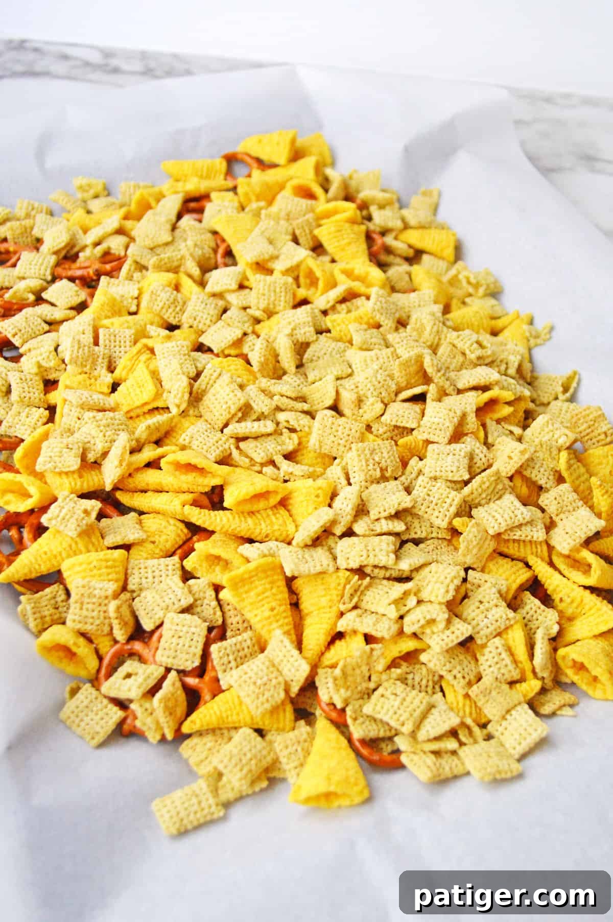Monster Mash Snack Mix 5 Chex cereal, bugles, and mini pretzel twists mixed together on lined baking sheet.