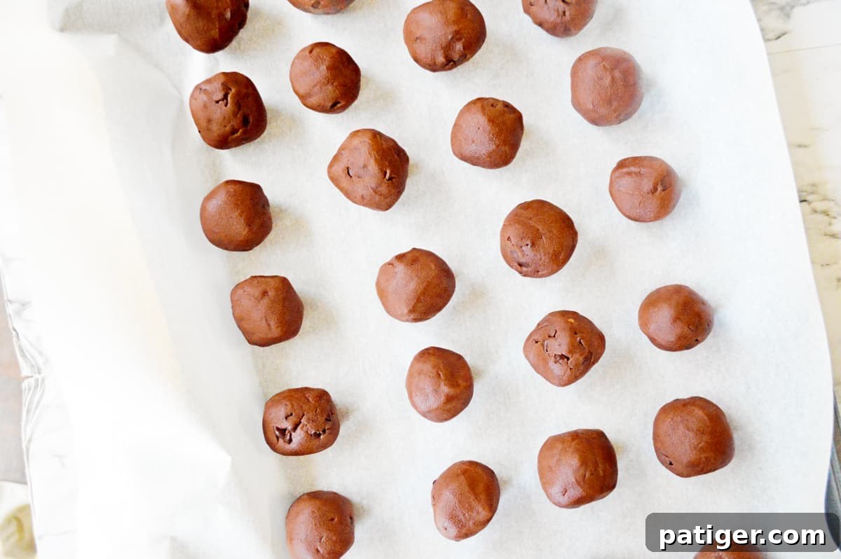Balls of chocolate cookie dough on baking sheet.