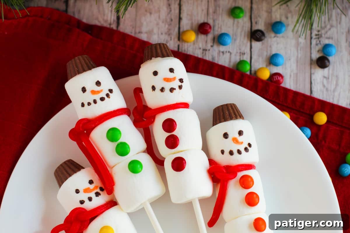 A collection of festive marshmallow snowman treats on sticks, perfect for hot cocoa stirrers.