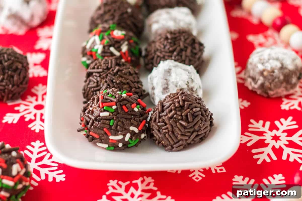 No bake chocolate rum balls served on white tray with Christmas decor.