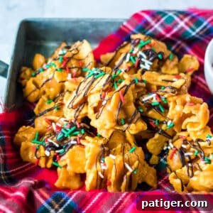 Peanut butter fritos candy topped with a drizzle of chocolate and Christmas sprinkles.