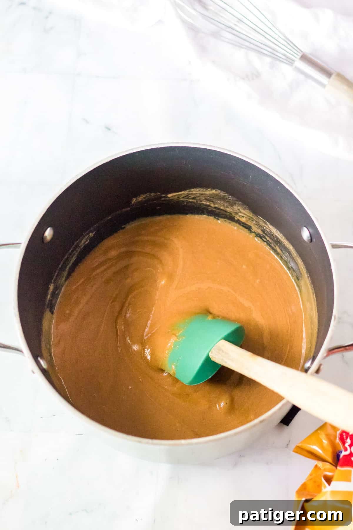 Saucepan with peanut butter mixture and rubber spatula.