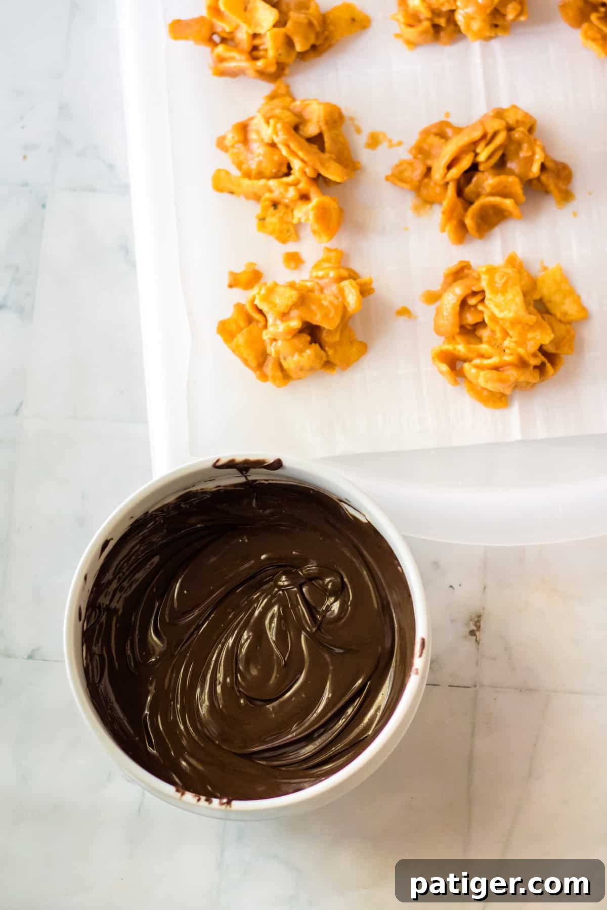 Bowl of melted chocolate next to fritos candy clusters.
