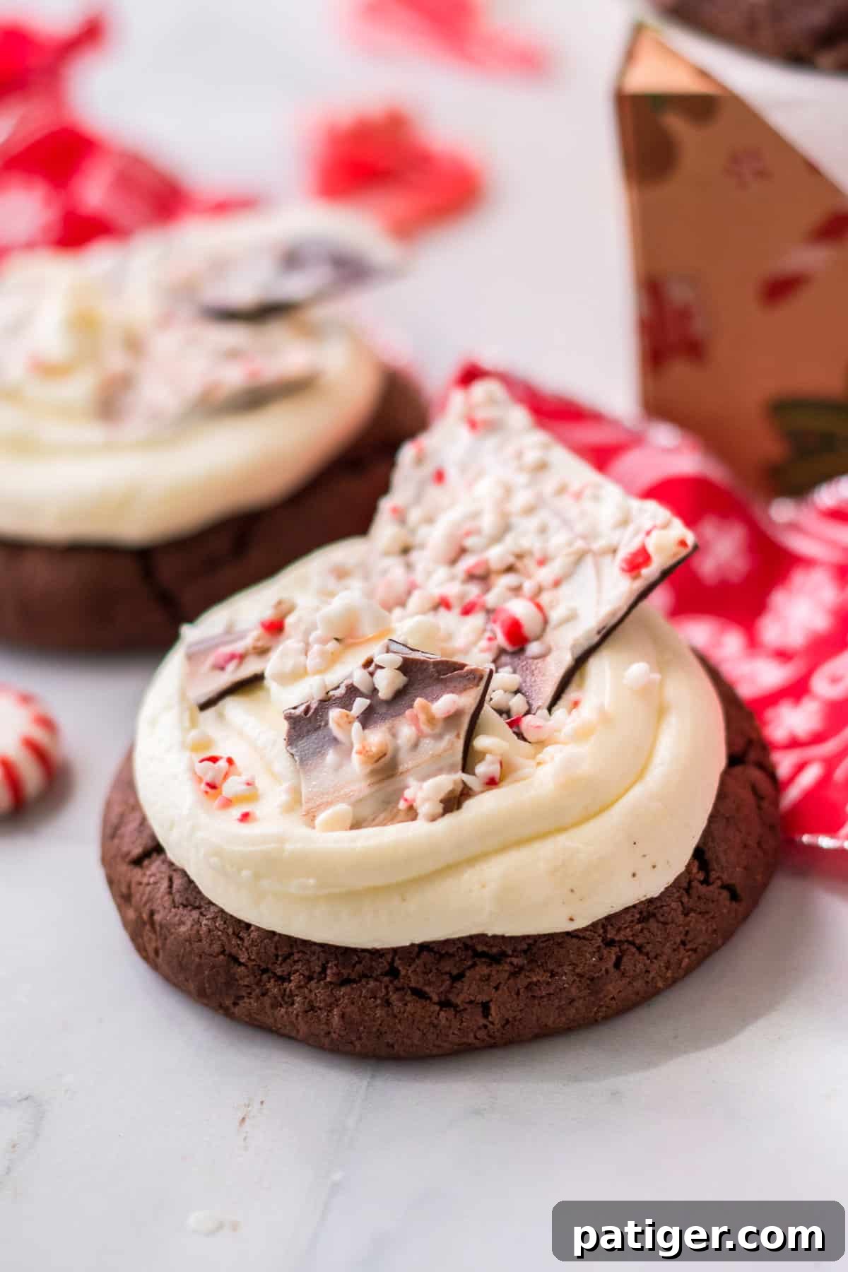 Thick chocolate cookie with buttercream frosting and shards of homemade peppermint bark.