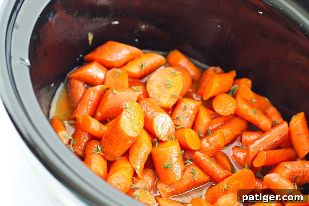 Perfectly glazed carrots simmering in the slow cooker, rich with a sweet and savory brown sugar coating.