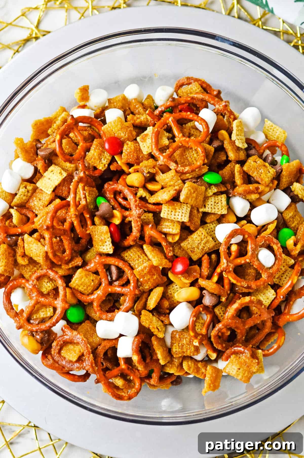 Holiday Hearth Mix 7 Christmas Chex mix with M&Ms and marshmallows in large mixing bowl.