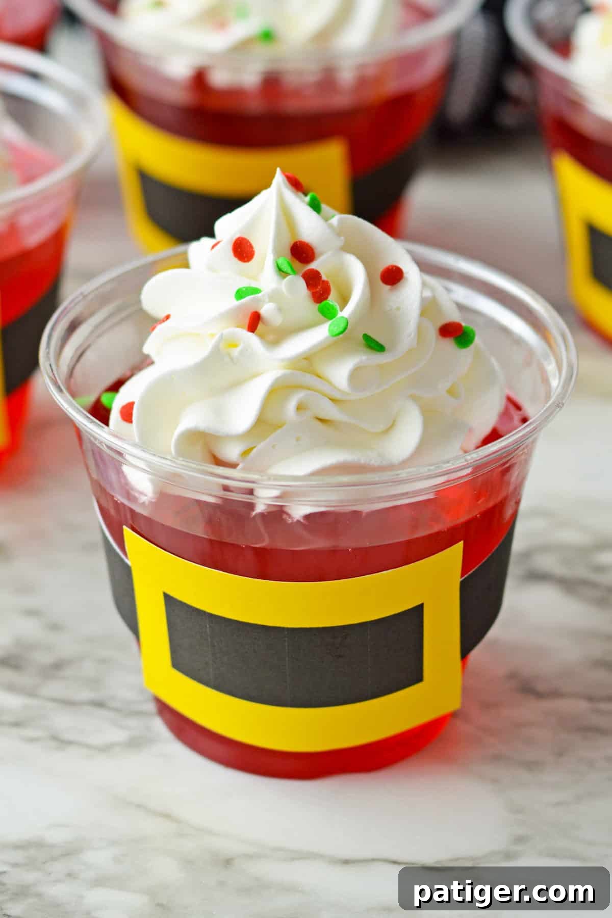 A completed Santa Jello Cup, adorned with its black and gold belt, standing out on a festive background.