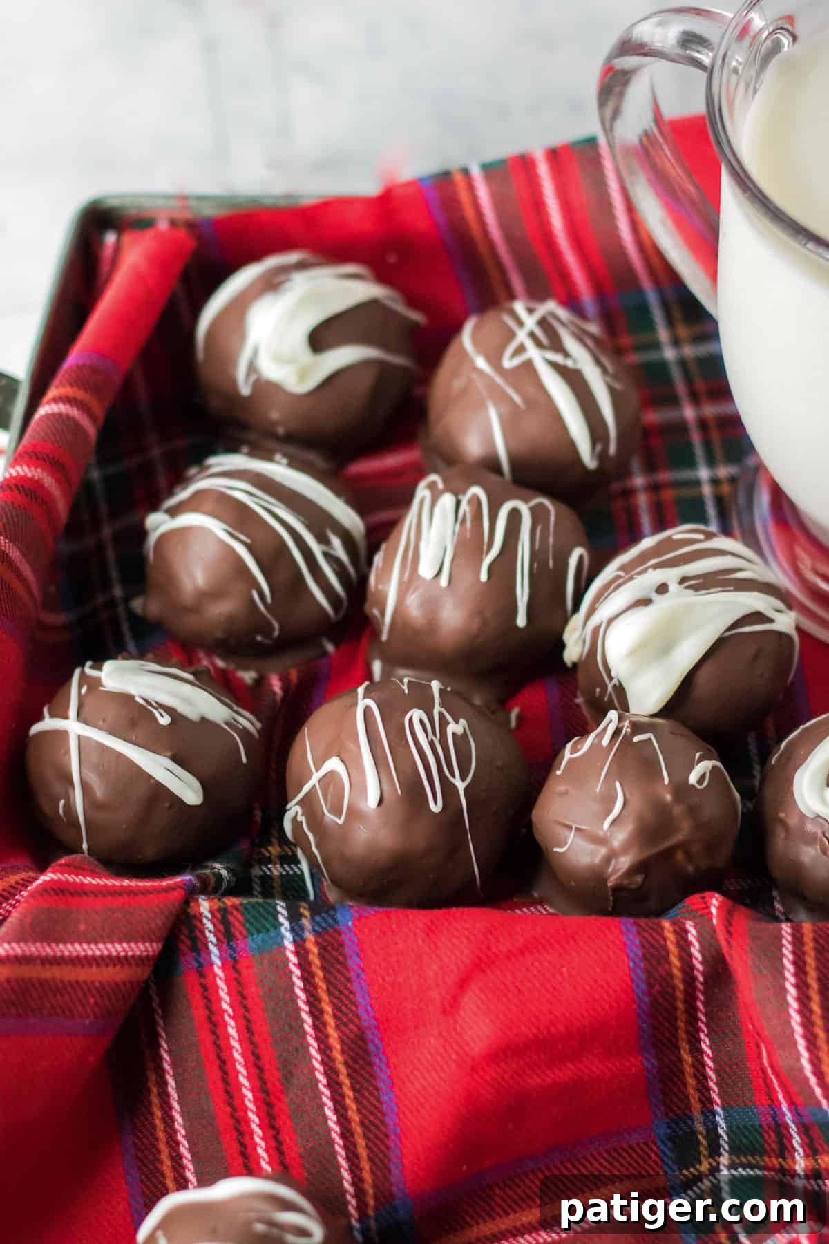 Decadent Martha Washington candy, chocolate-coated coconut-pecan-cherry candies, beautifully drizzled with white chocolate and presented in a festive Christmas tin, ready for holiday gifting.