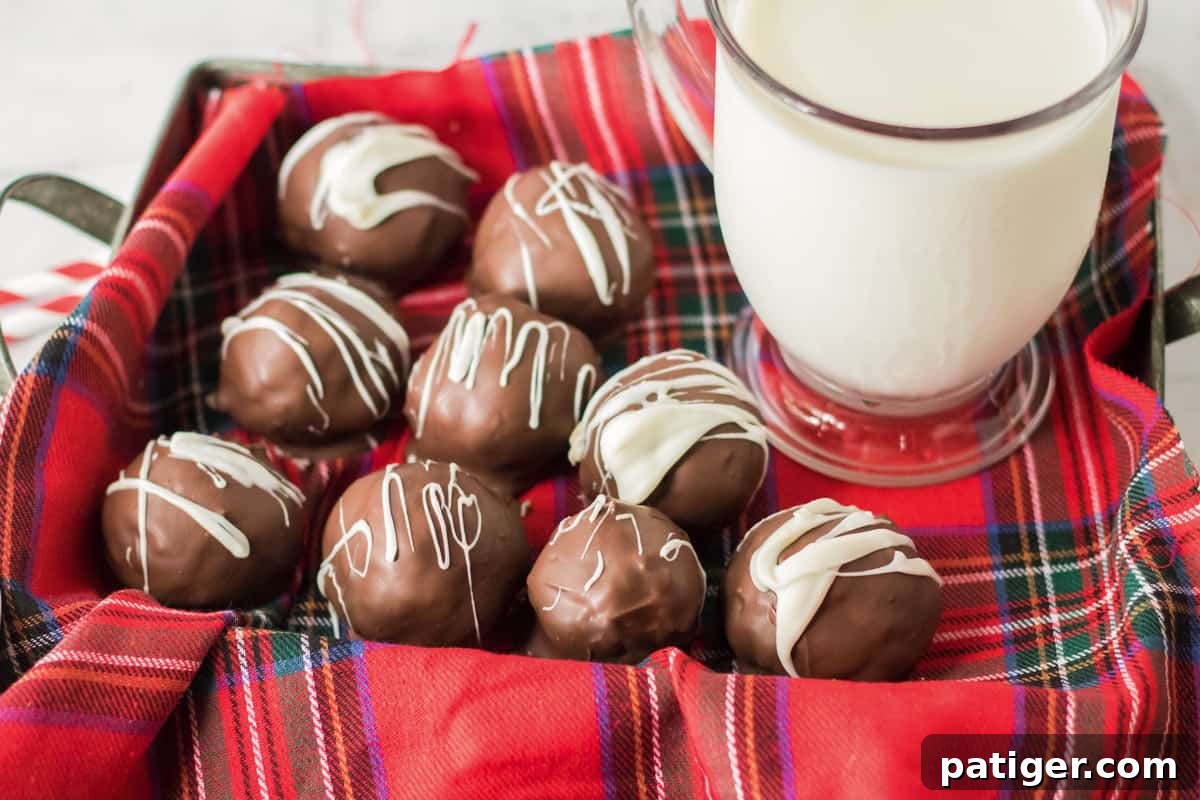 Beautifully finished Martha Washington candy, chocolate-coated and white chocolate-drizzled, presented in a festive Christmas tin, highlighting their homemade charm.