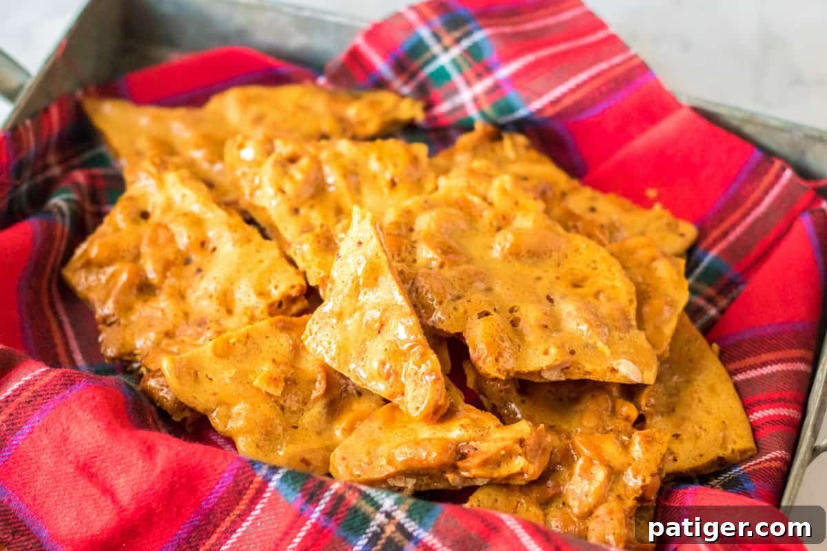 Instant Peanut Brittle 3 A festive Christmas candy tin filled with sparkling, broken pieces of homemade microwave peanut brittle, ready for gifting.