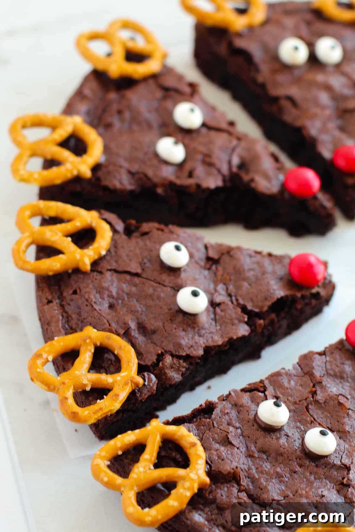 Close-up shot of rich chocolate brownies, artfully decorated with golden pretzels as antlers and playful candies to bring reindeer faces to life.