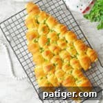 Crescent rolls baked in the shape of a Christmas tree, ready for sharing.