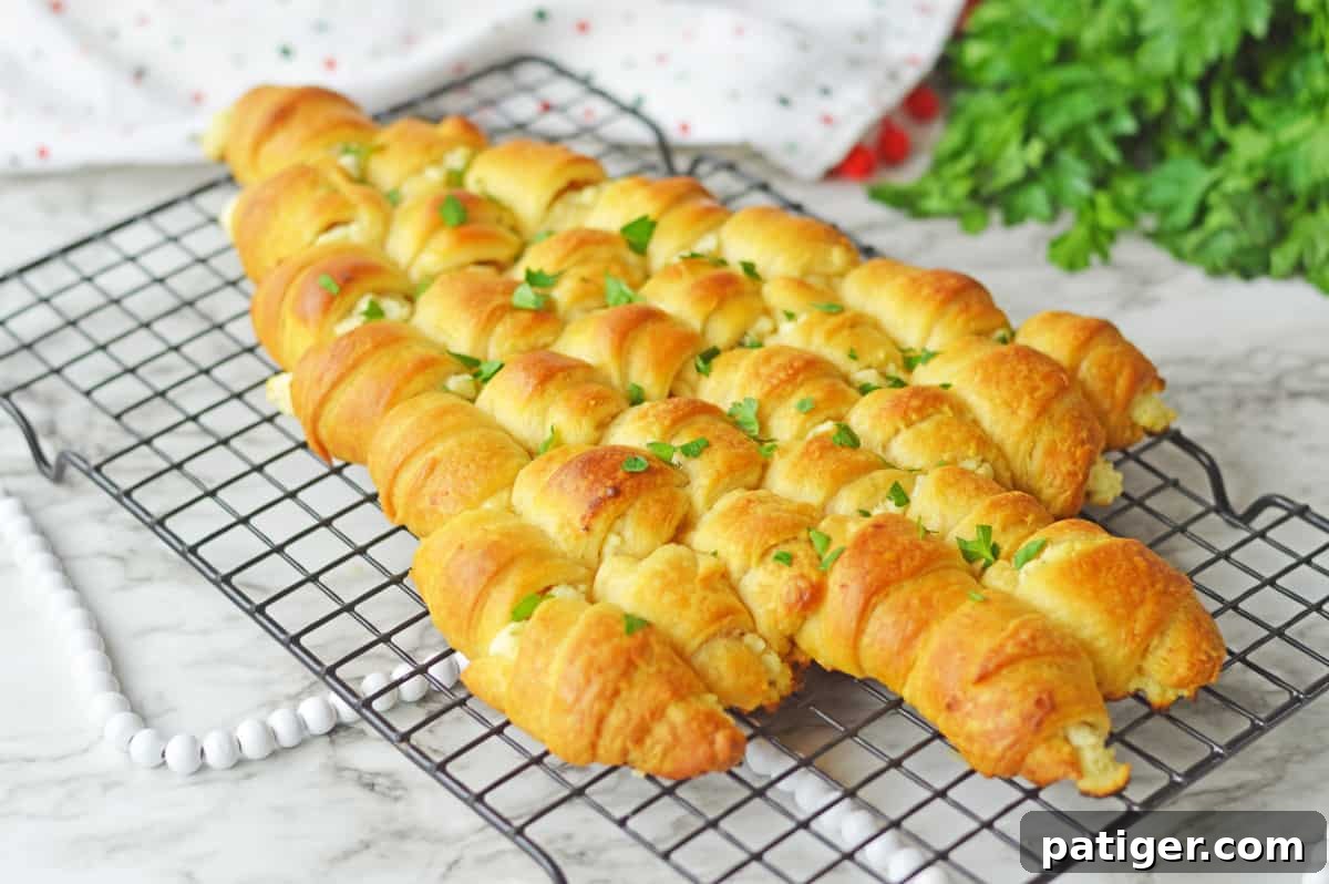 Cheese-stuffed crescents artfully arranged in the shape of a Christmas tree on a wire rack, perfectly poised for baking.