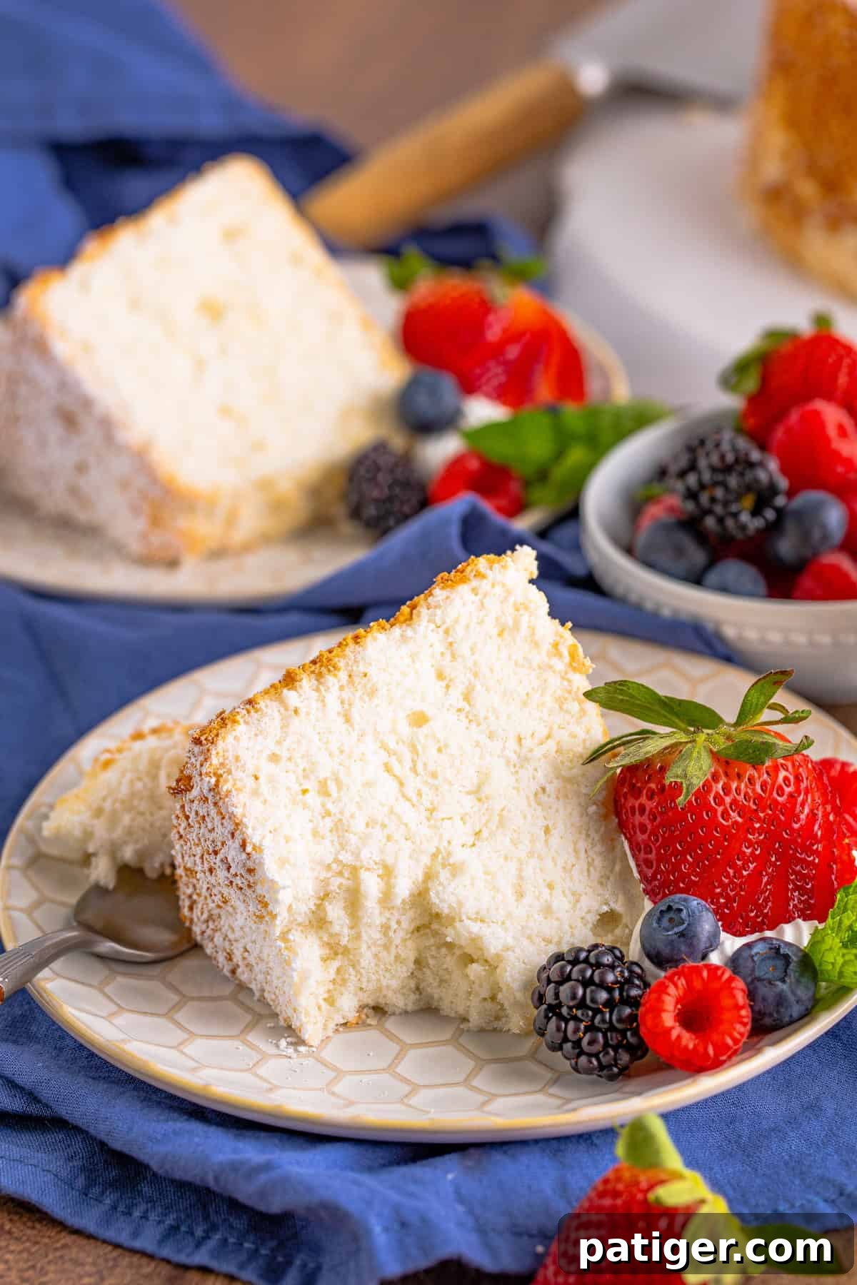 Feather-Light Angel Food Dream 14 A close-up shot of a slice of light and fluffy angel food cake with a forkful removed, showcasing its incredibly tender and airy texture, dusted with powdered sugar.