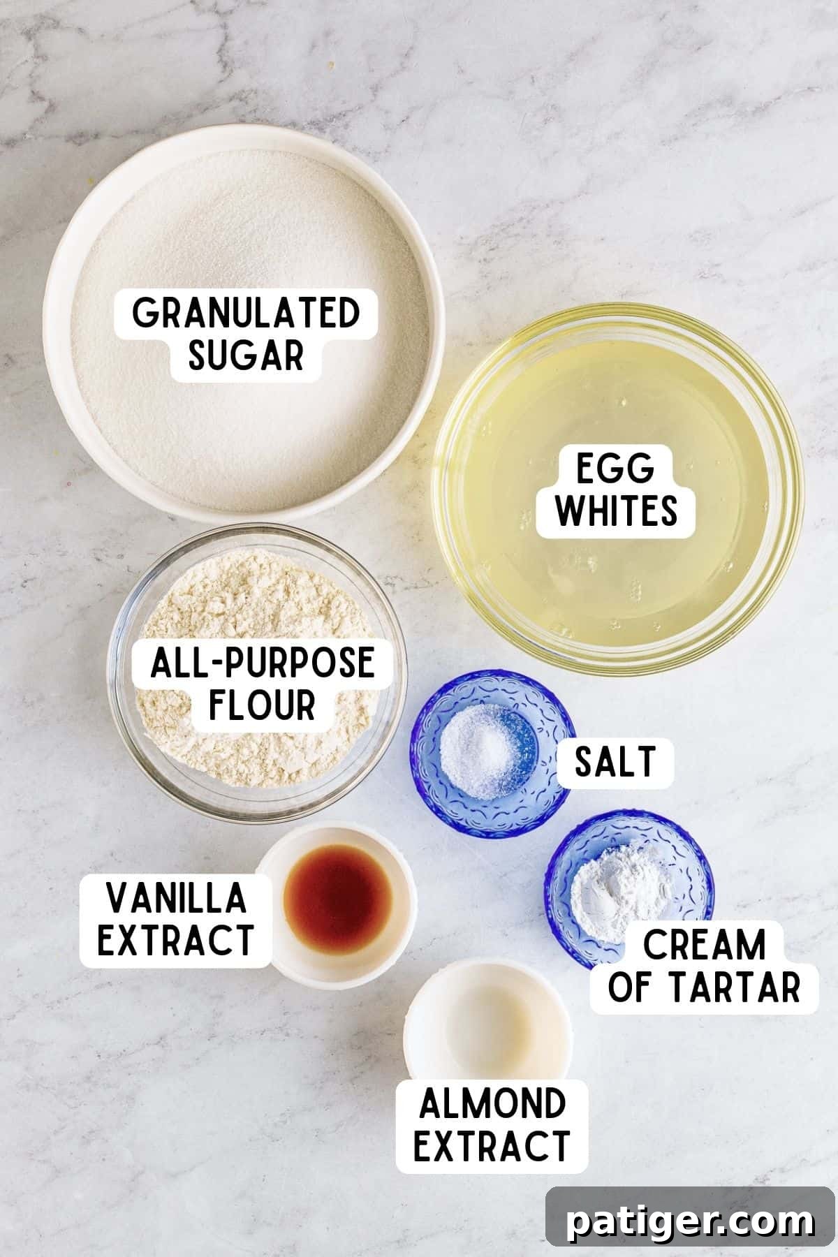 Feather-Light Angel Food Dream 4 A flat lay photograph showcasing the seven simple ingredients required for homemade Angel Food Cake: granulated sugar, all-purpose flour, salt, egg whites, cream of tartar, vanilla extract, and almond extract.