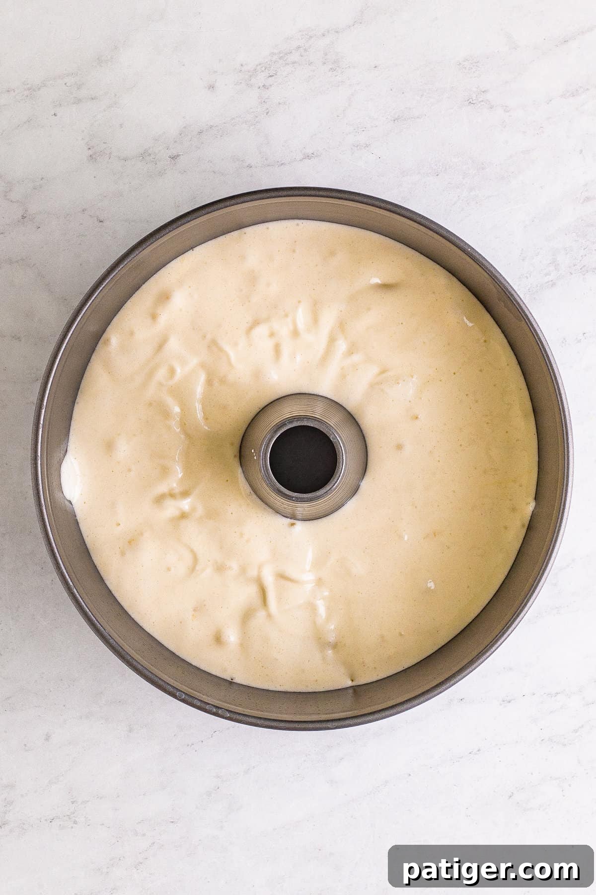 Feather-Light Angel Food Dream 9 Light and airy angel food cake batter evenly distributed in an ungreased tube pan, ready for baking.