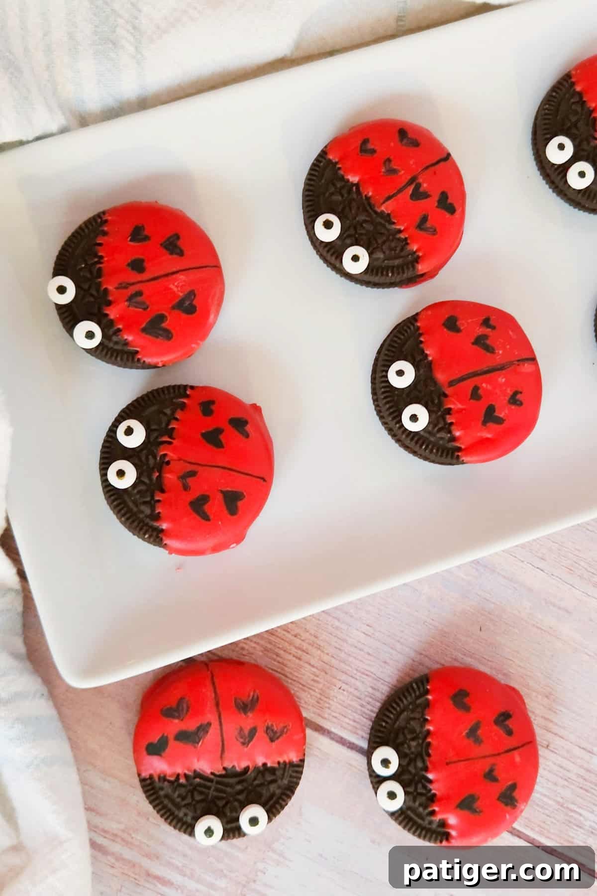 Oreo cookies decorated like love bugs arranged on a white platter.