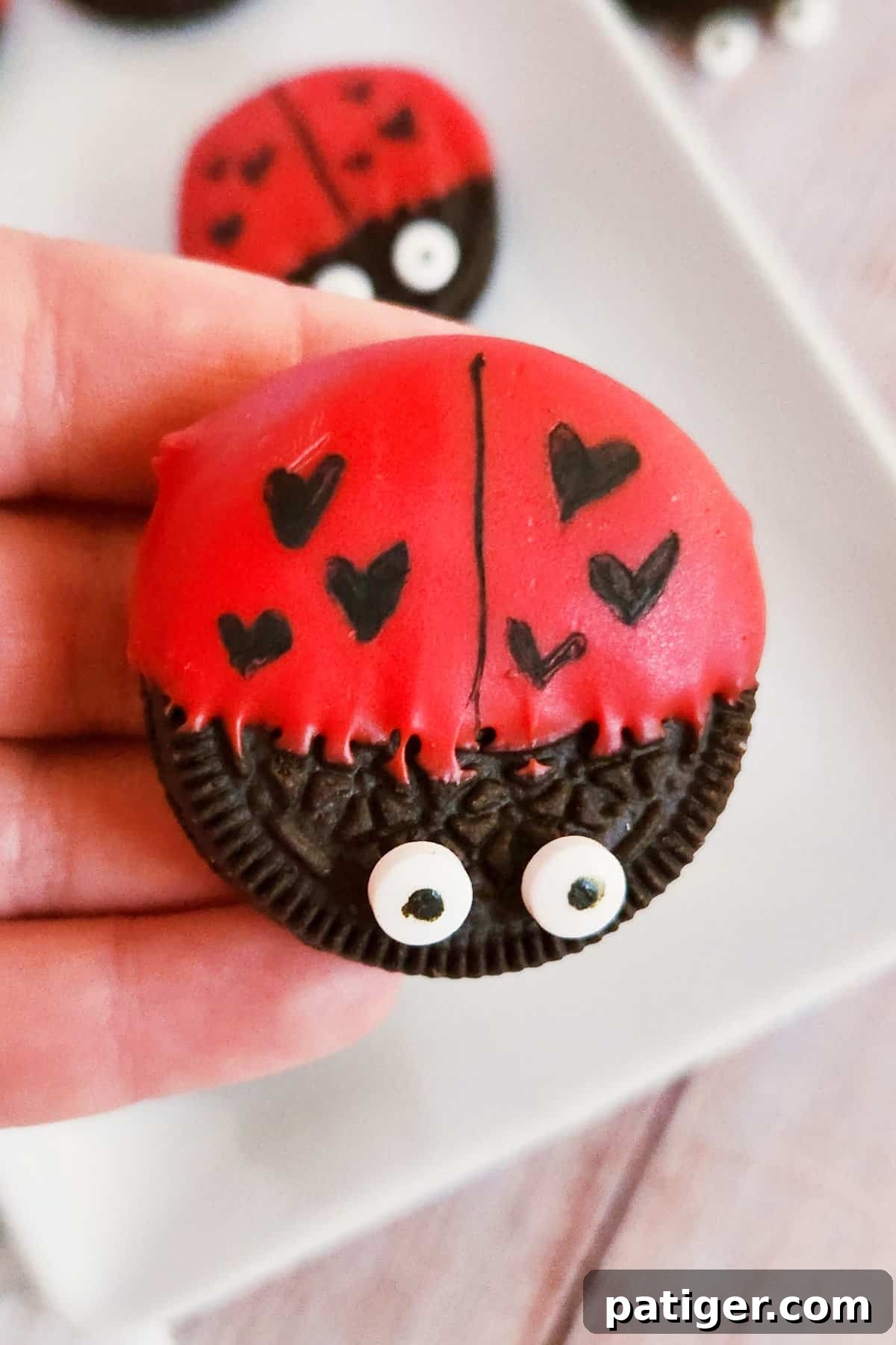 Hand holding a Valentine Oreo love bug.