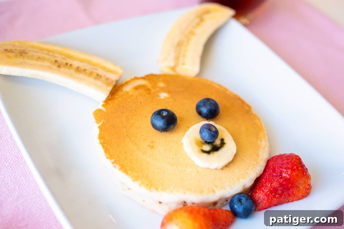 Pancake decorated with fresh fruit to look like a bunny rabbit, a simple and fun breakfast.