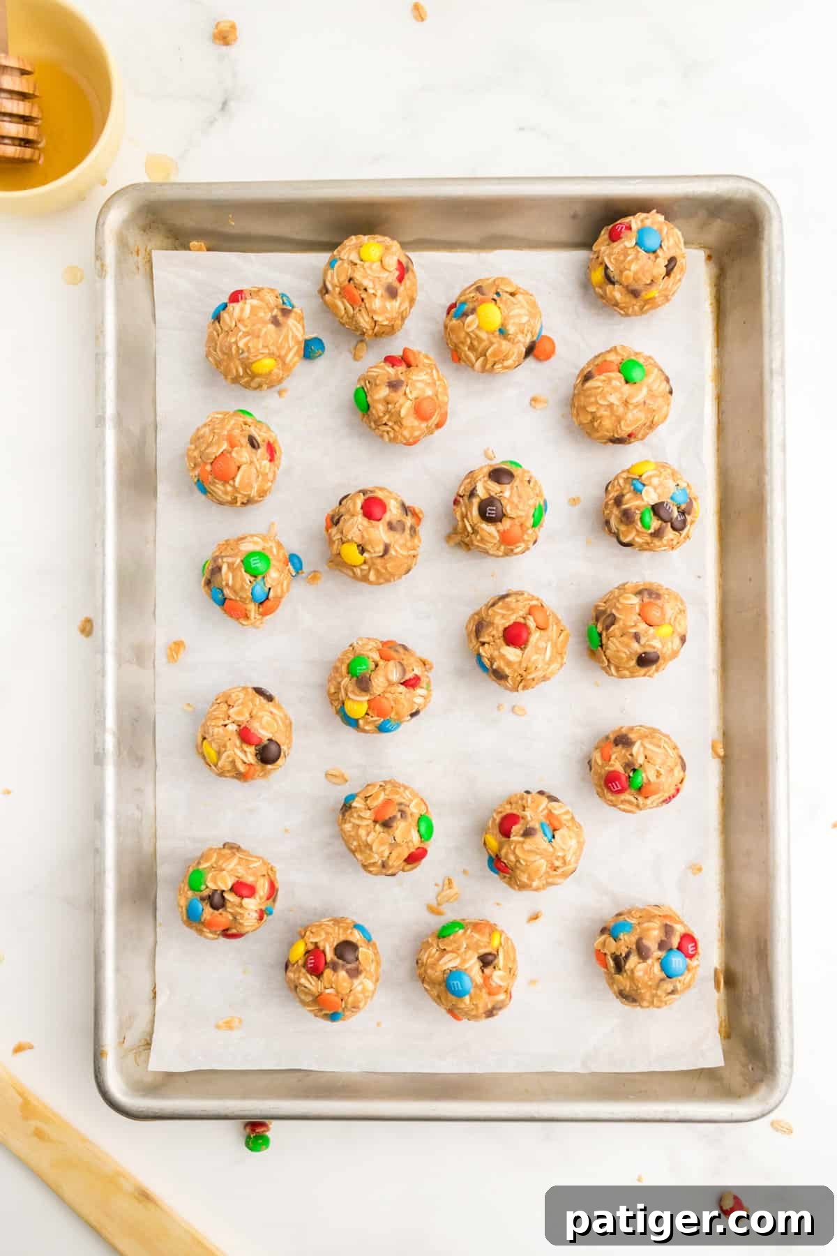 No-Bake Monster Cookie Energy Bites 7 Monster Energy Cookie Balls on lined baking sheet.