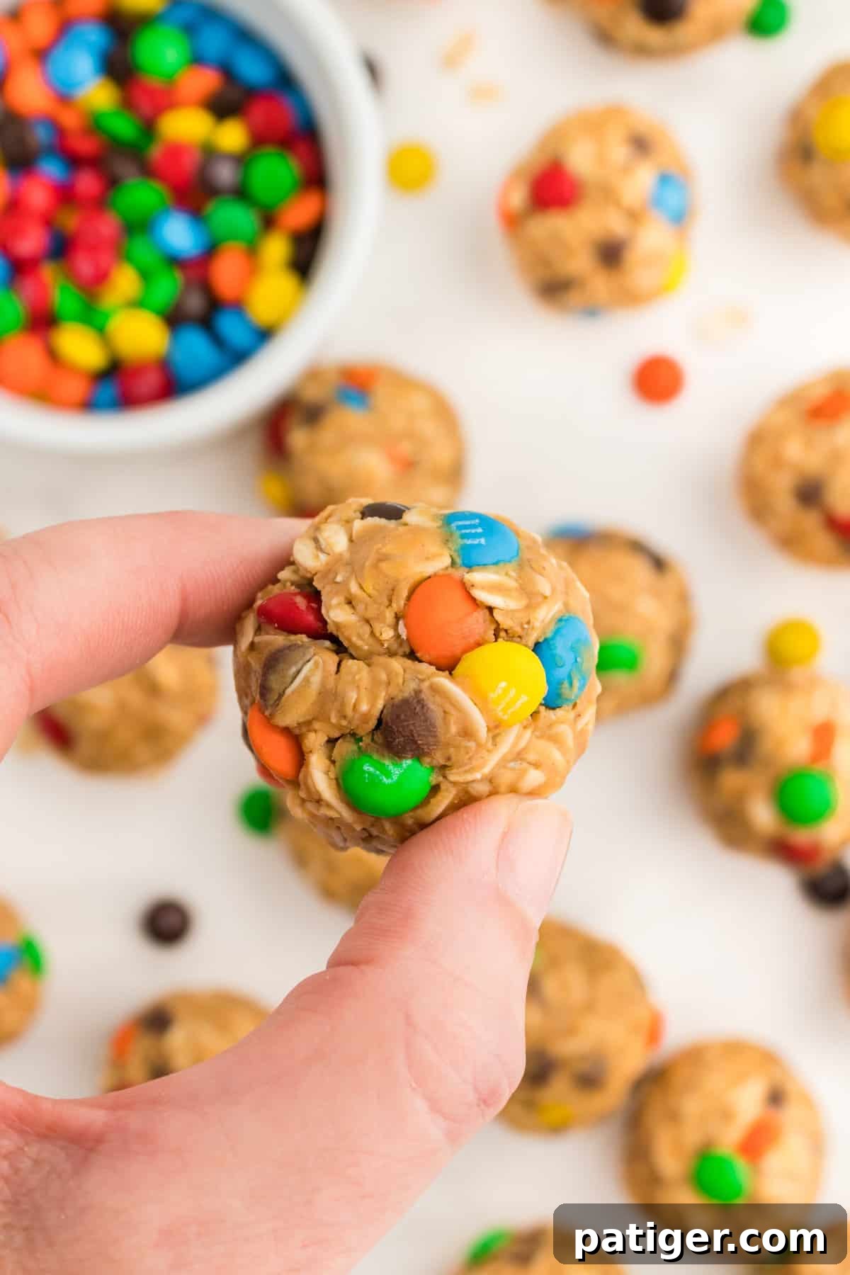 No-Bake Monster Cookie Energy Bites 8 Thumb and forefinger holding a monster energy bite.