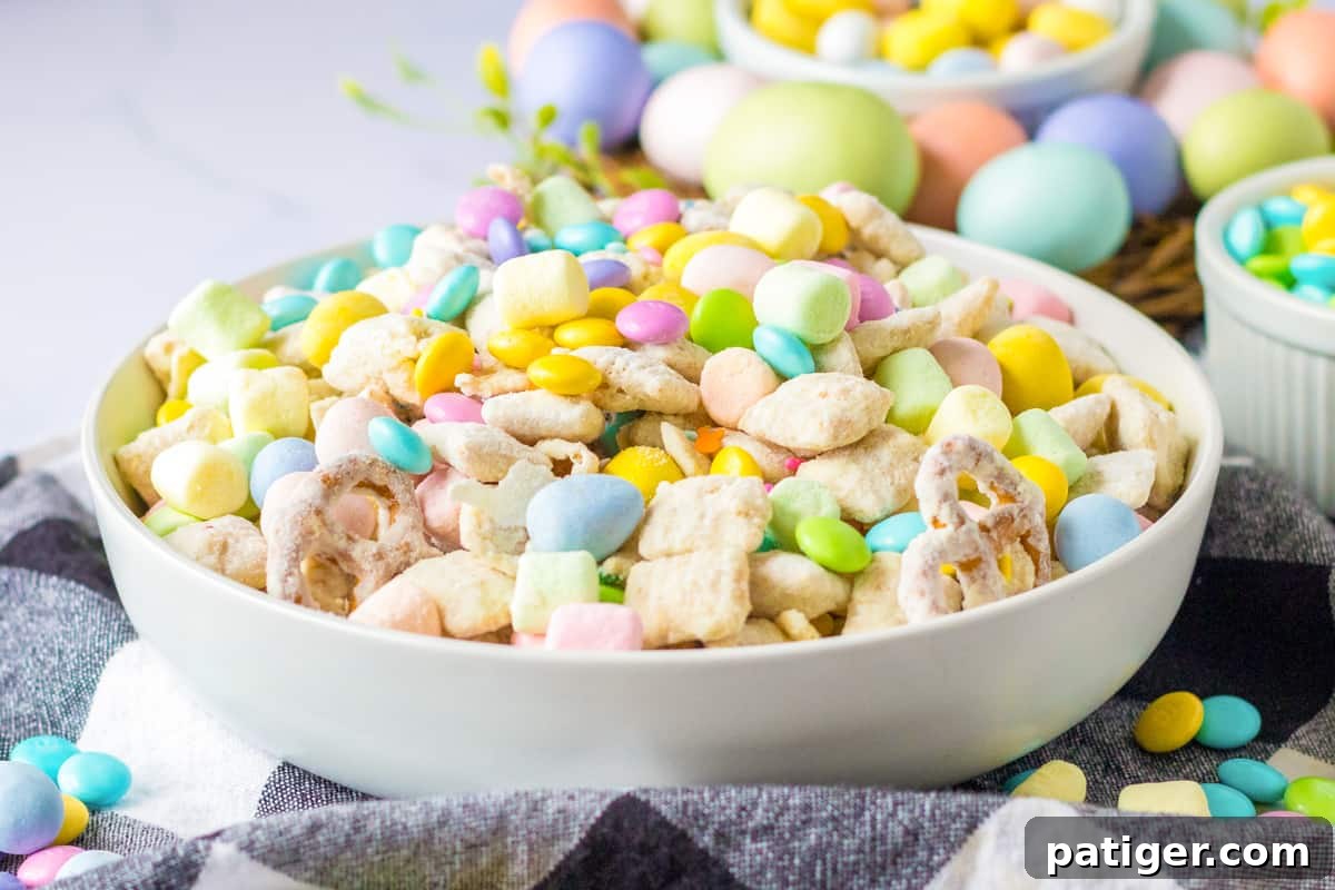 Easter muddy buddy snack mix with funfetti coated rice chex, pretzels, mini eggs, mini marshmallows, and pastel sprinkles and m&ms.