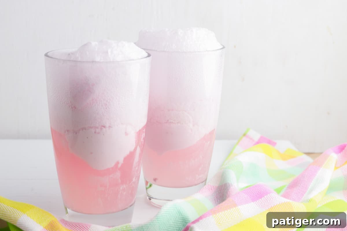 Vibrant Easter Elixir 6 Pink strawberry punch fizzing and bubbling in glasses as carbonated soda is combined with ice cream, creating a frothy top.