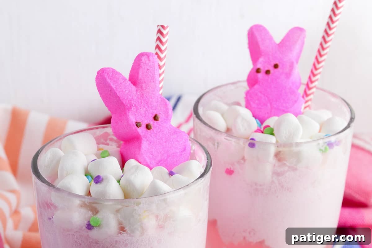 Vibrant Easter Elixir 7 A finished glass of Easter Punch, beautifully topped with mini marshmallows, confetti-style sprinkles, a pink marshmallow Peeps bunny, and a decorative pink and white paper straw.