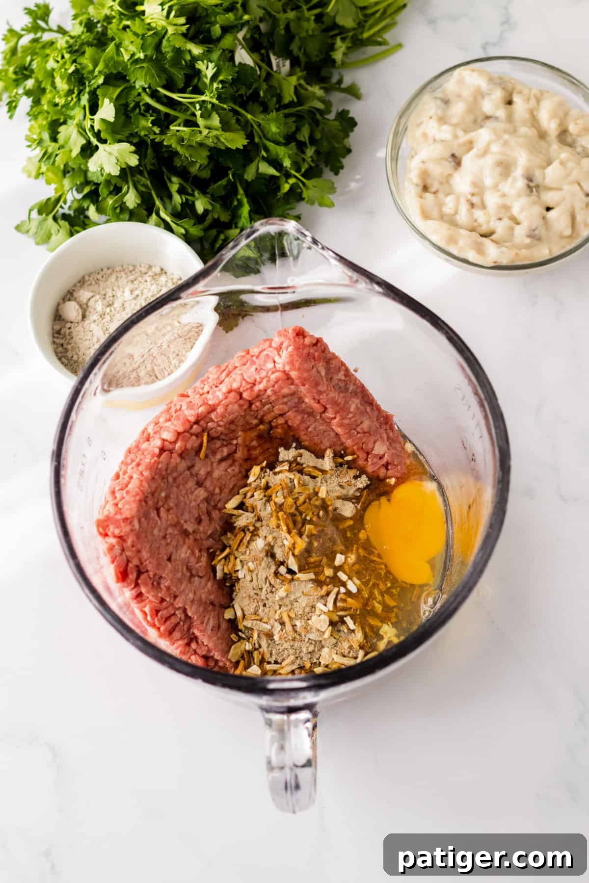 Tender Slow Cooker Salisbury Steaks 5 Ground beef, onion soup mix, egg, bread crumbs, worcestershire sauce, and steak seasoning in a large measuring cup.