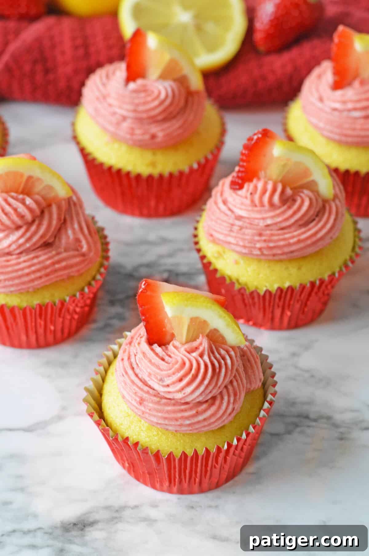 Pink Lemonade Swirl Cupcakes 3 Lemon and strawberry cupcakes topped with a smooth, pink strawberry lemonade frosting and delicate garnishes.