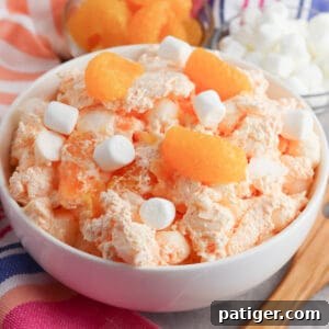 Orange fluff salad with mini marshmallows, mandarin oranges, and jello.