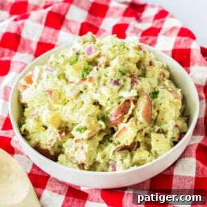 Bowl of red skinned potato salad on a red plaid linen.