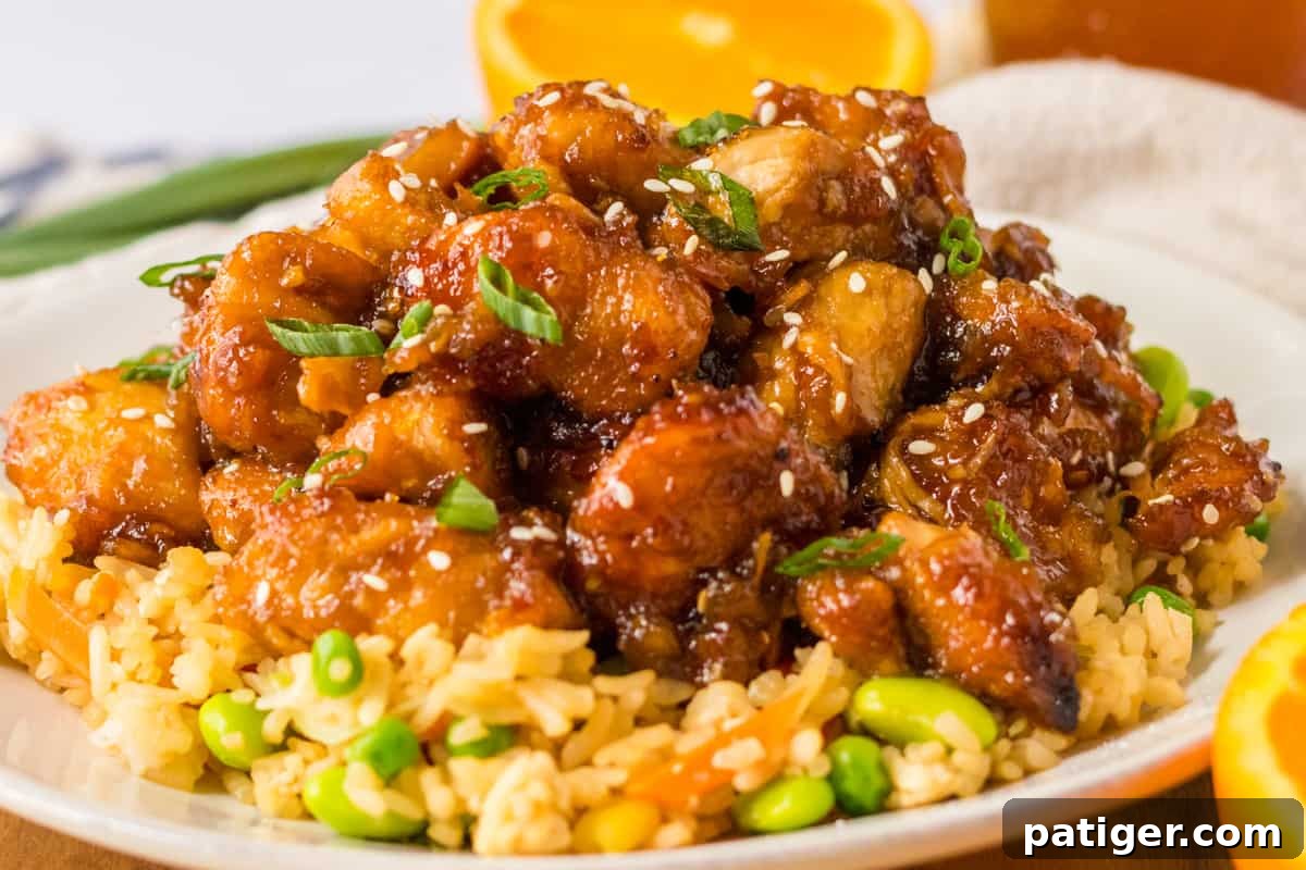 Crock pot orange chicken served over bed of vegetable fried rice.