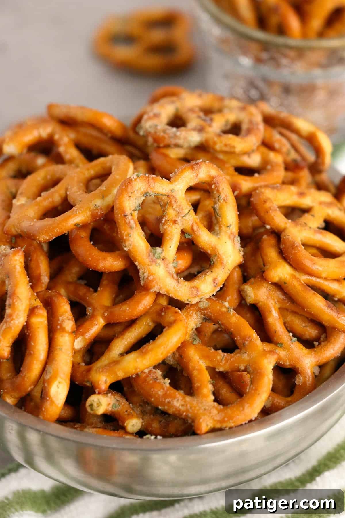 A silver bowl overflowing with perfectly seasoned garlic ranch pretzels, ready for snacking.