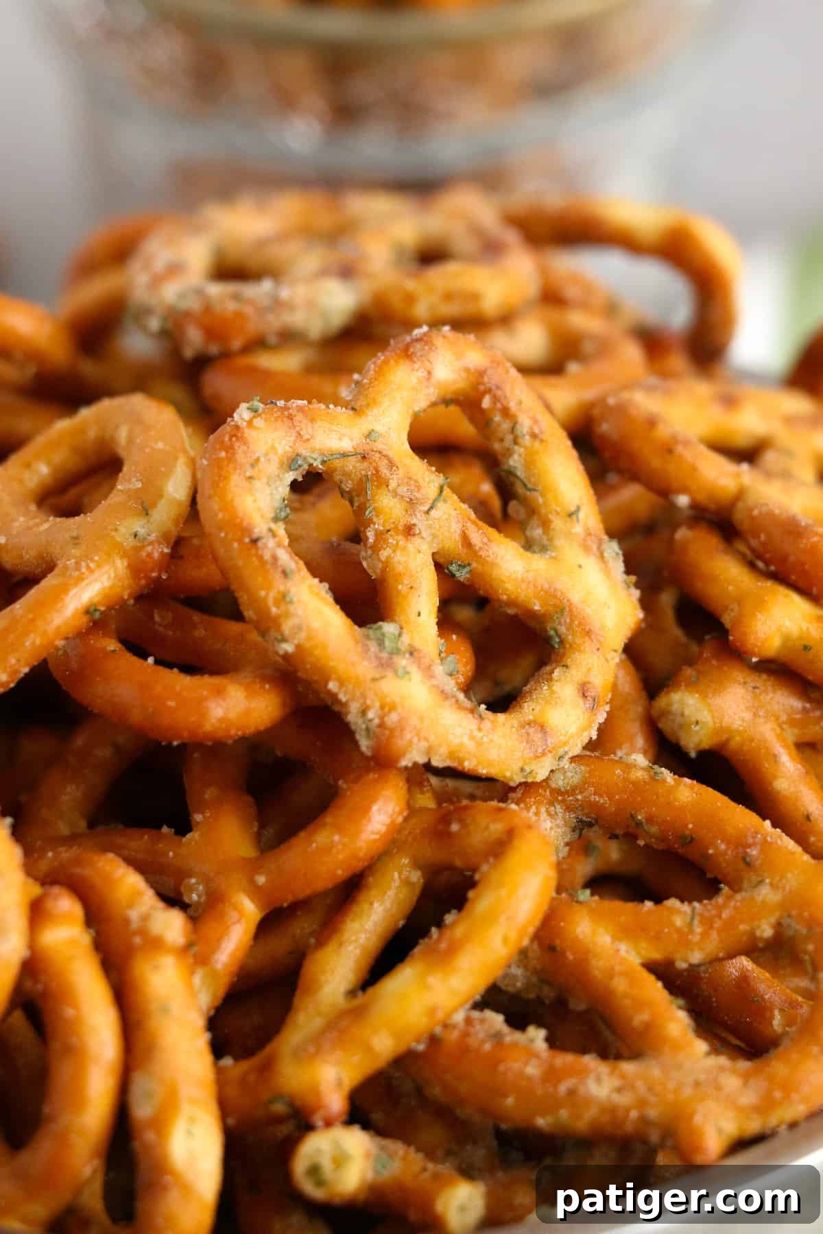 A close-up shot of perfectly seasoned garlic ranch pretzels in a silver bowl, showcasing their golden-brown color and rich seasoning.