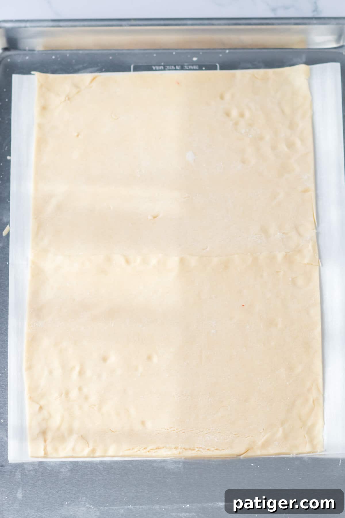 Rectangular pie crust on parchment lined baking sheet.