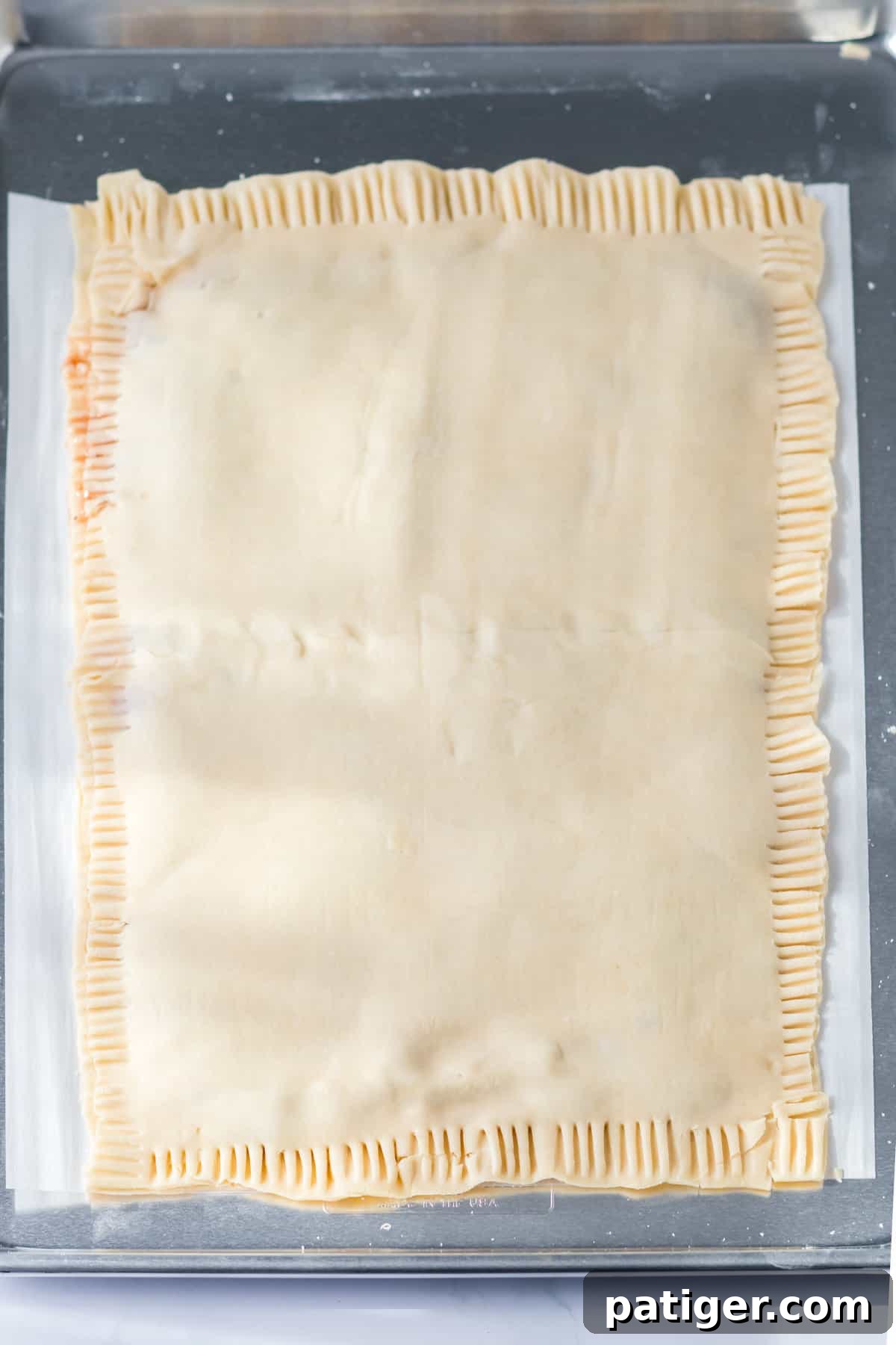 Top layer of pie crust placed over bottom layer and edges crimped with fork.