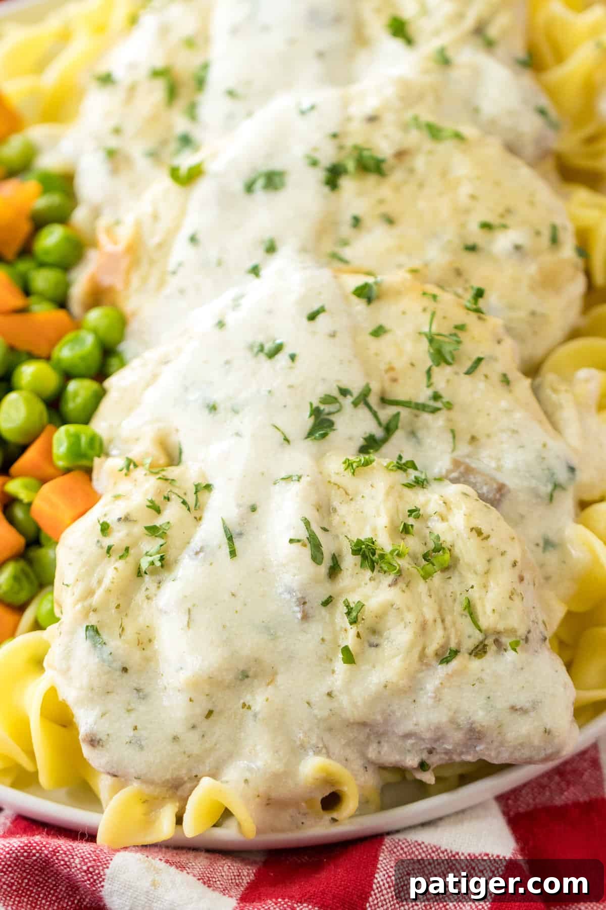 Effortless 4-Ingredient Oven Baked Pork Chops 3 Creamy oven baked pork chops with cream of mushroom sauce and parsley garnish served with noodles and mixed vegetables.