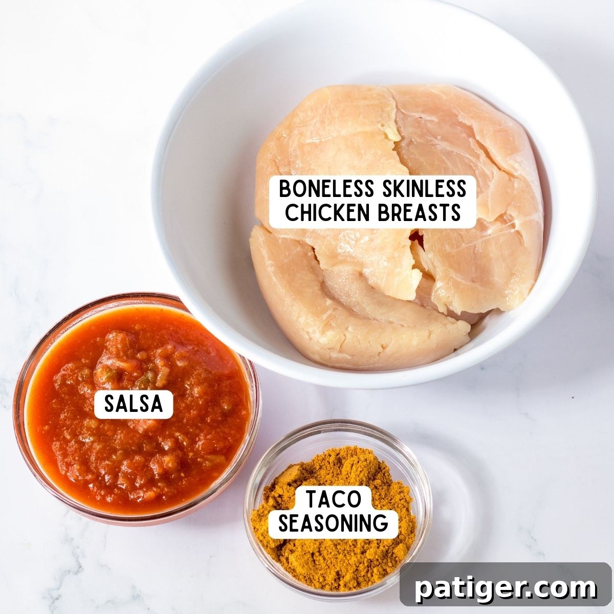 Boneless skinless chicken breasts, a jar of salsa, and a packet of taco seasoning laid out.