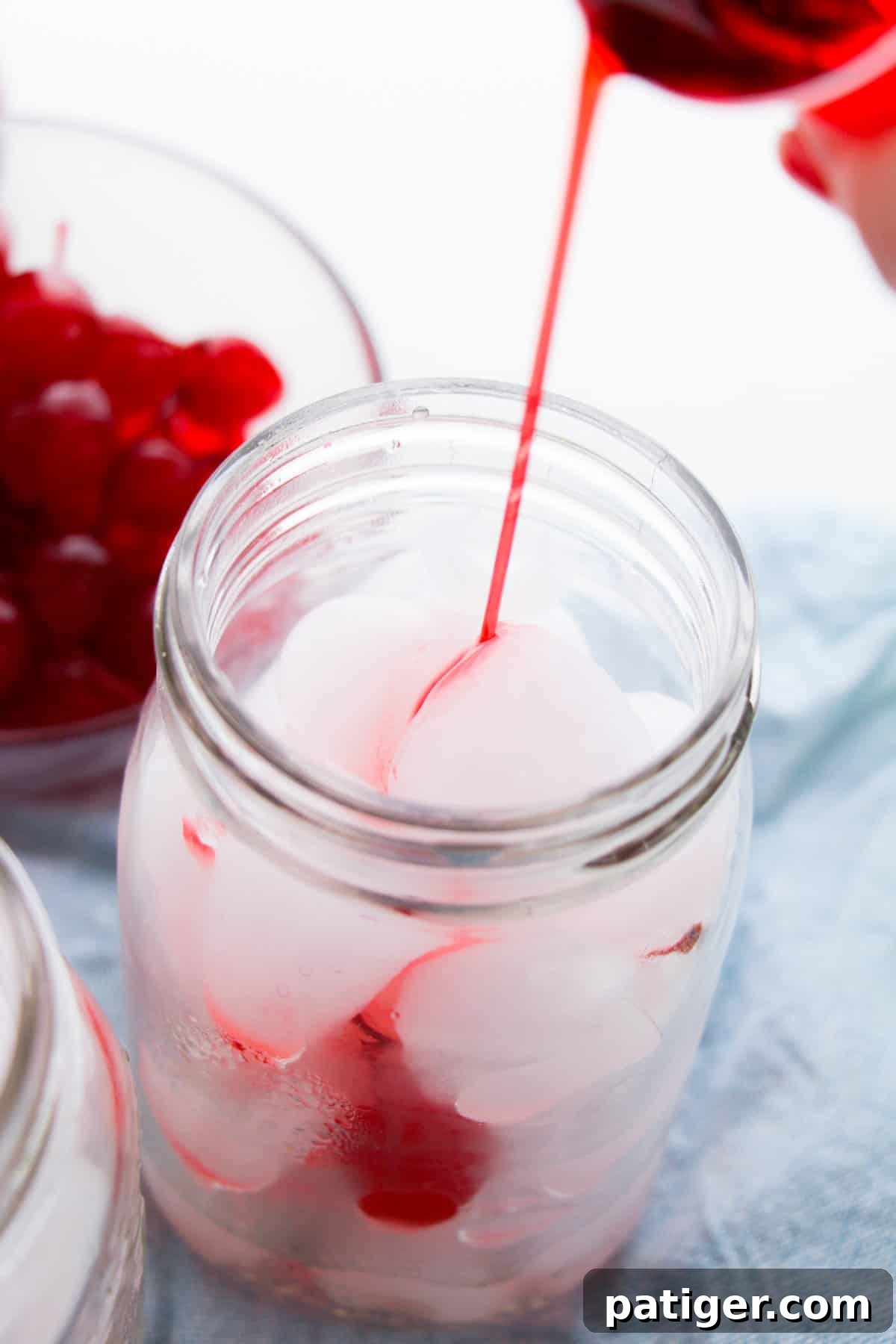 Shirley Temple Cream Soda 4 Grenadine being poured into ice-filled mason jar.
