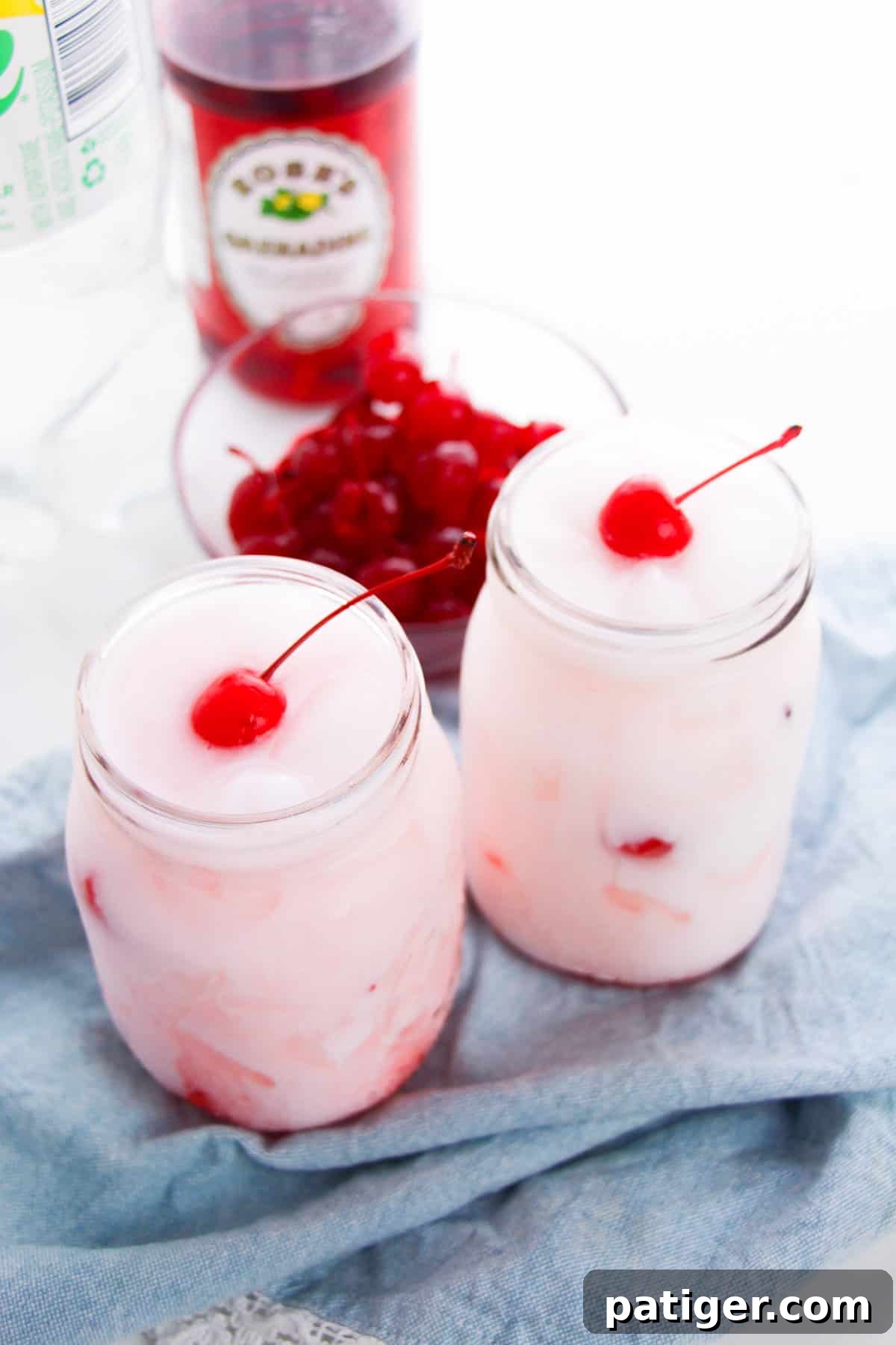 Shirley Temple Cream Soda 7 Two Shirley Temple Dirty sodas in mason jars with a bottle of grenadine in the background.