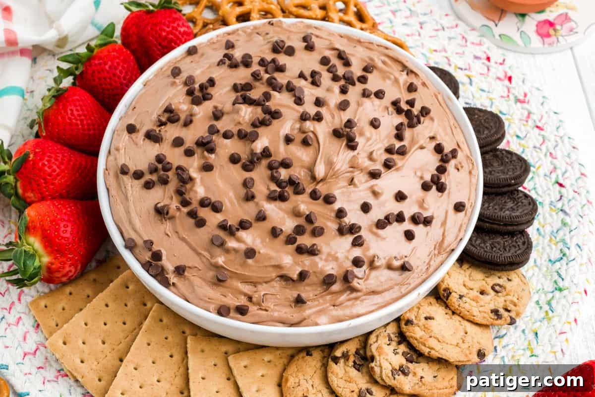 Edible Brownie Batter Dream 11 Bowl of brownie batter dip served with strawberries, cookies, and graham crackers for dipping.