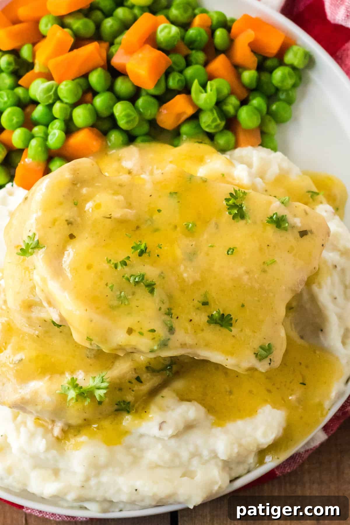 Melt-in-Your-Mouth Slow Cooker Ranch Pork Chops 2 3 Ingredient crock pot pork chops with ranch dressing mix served over mashed potatoes with a side of veggies.