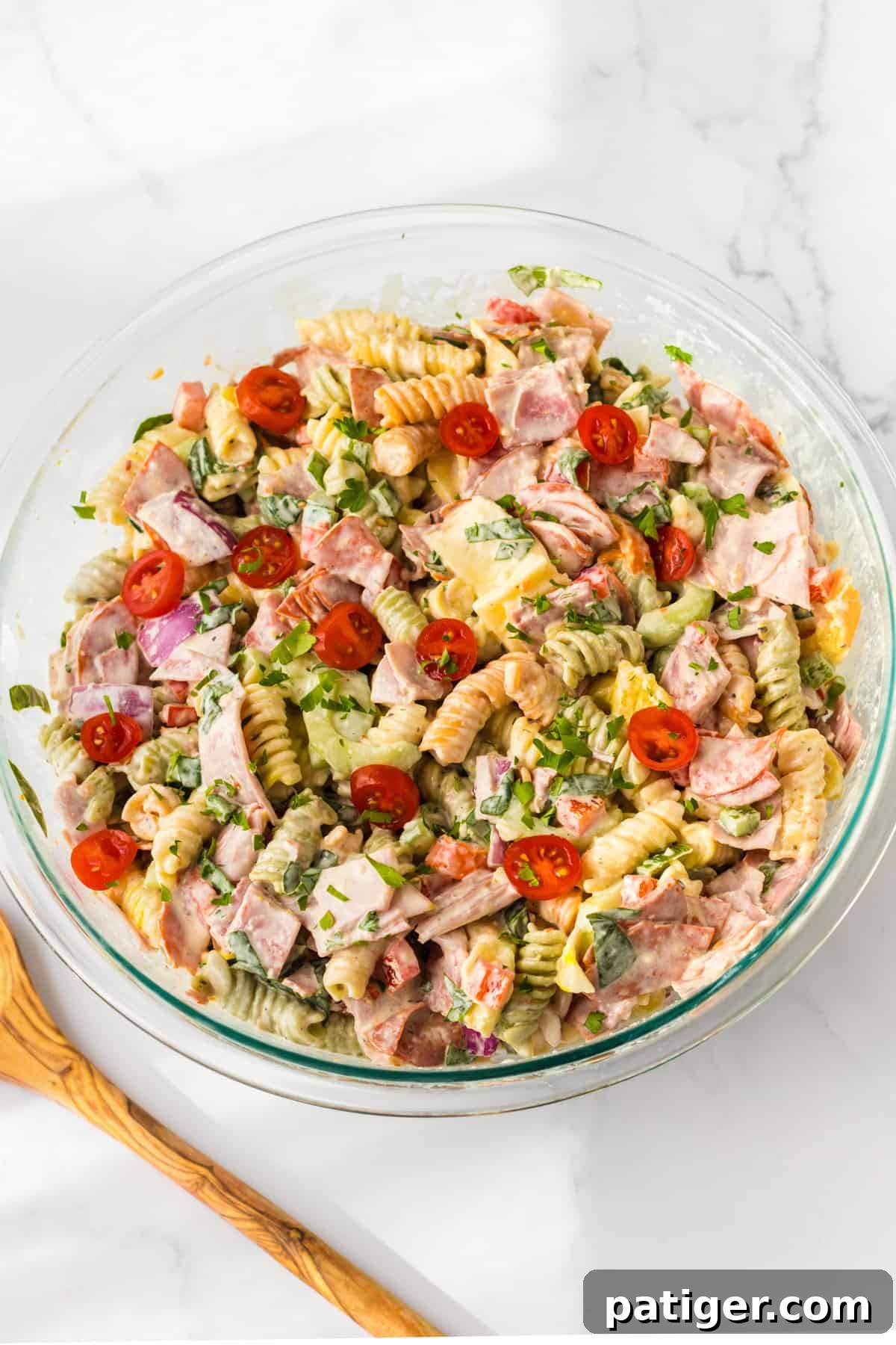 Italian Hoagie Pasta Salad 7 A large glass bowl filled with a delightful cold meat pasta salad, perfectly tossed and ready to serve.