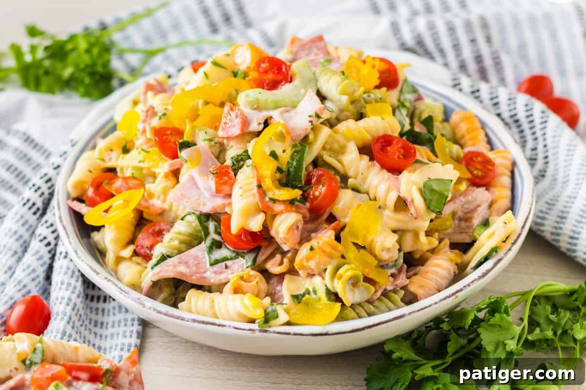 Italian Hoagie Pasta Salad 9 Close-up shot of Italian sub pasta salad, featuring generous pieces of ham, salami, and provolone cheese, mixed with pasta and fresh ingredients.