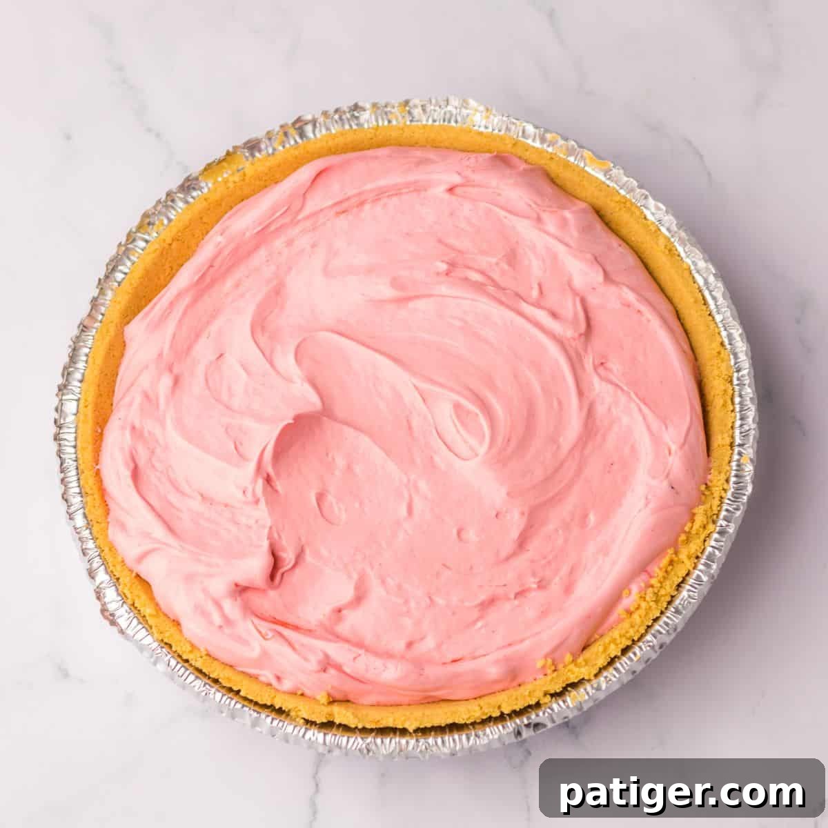 Summer Sip Pie 7 A graham cracker pie crust already filled with the smooth and colorful Kool-Aid mixture, showing the pie ready for chilling.