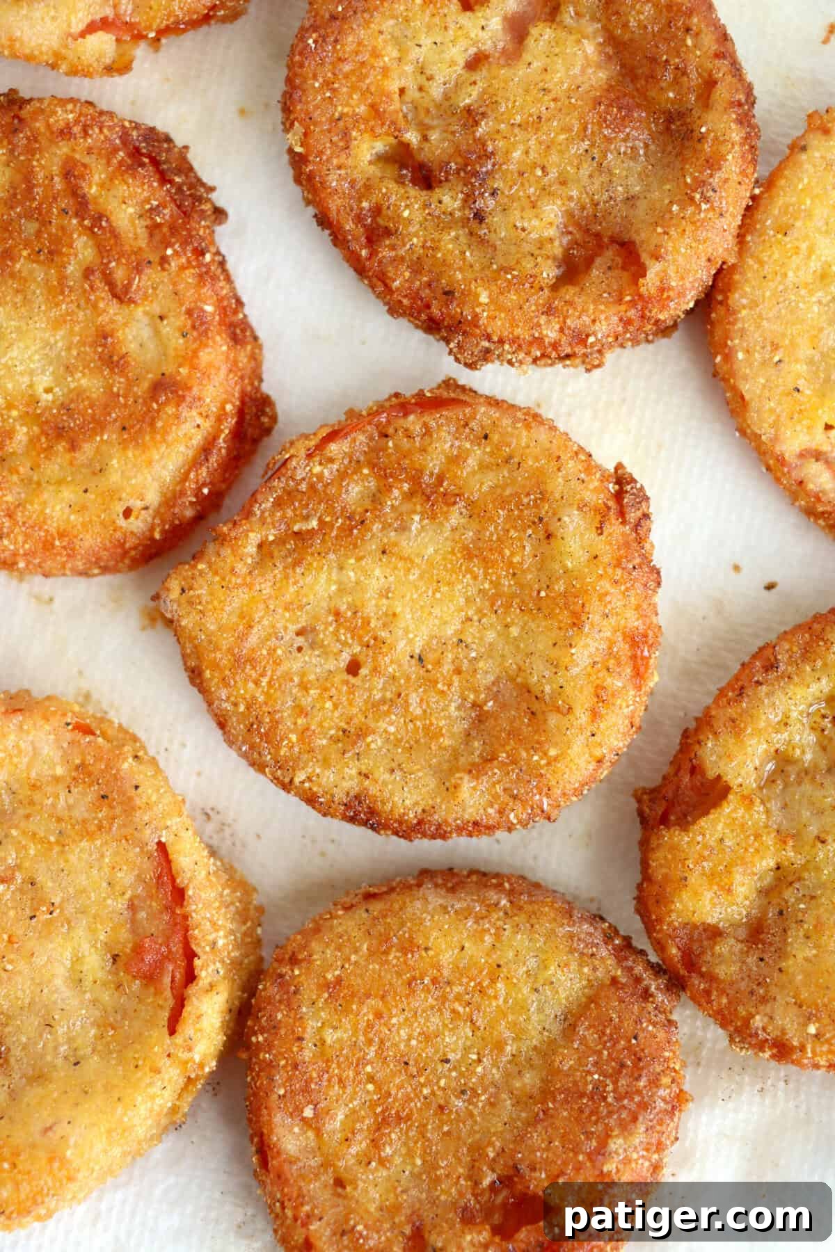 Freshly fried red tomatoes on paper towel.