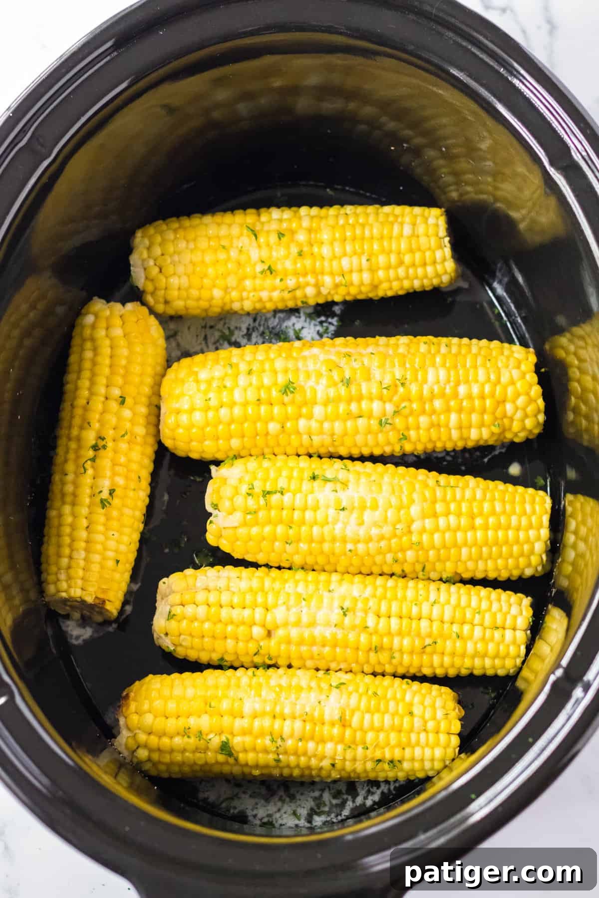 Set It and Forget It Corn on the Cob 7 Slow cooker corn on the cob, beautifully seasoned with butter, salt, and herbs, ready for serving.